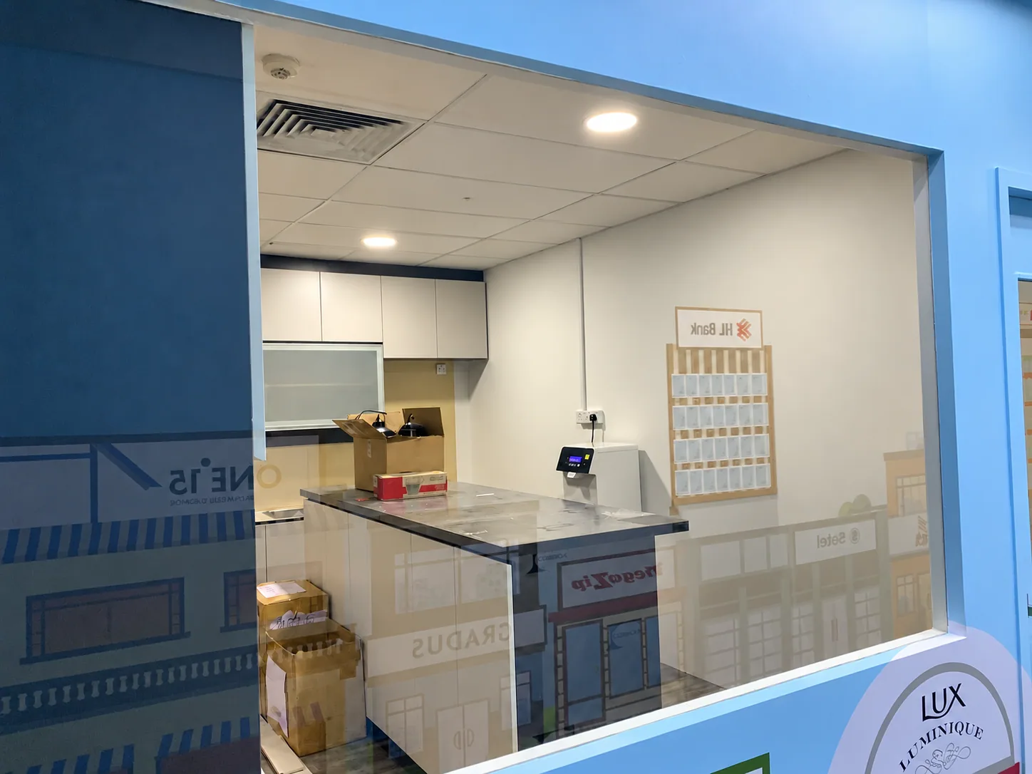 Glazed enclosure with white storage cabinets in the printing-company office