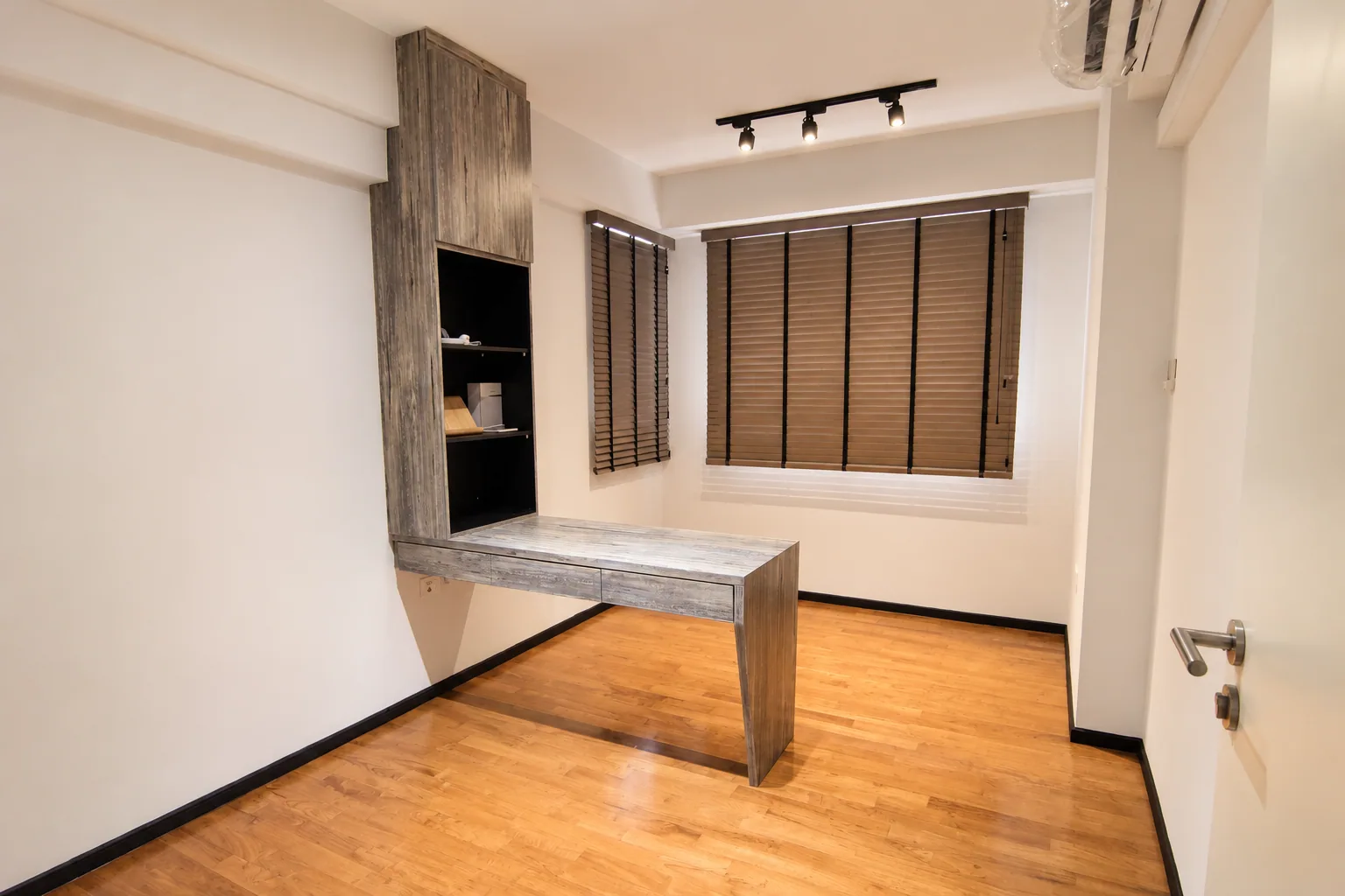 Punggol study with a fitted wood-look desk, tall shelving and wooden blinds