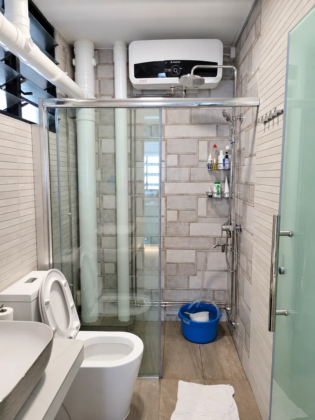 Toh Guan bathroom with glazed shower and pale grey wall finishes