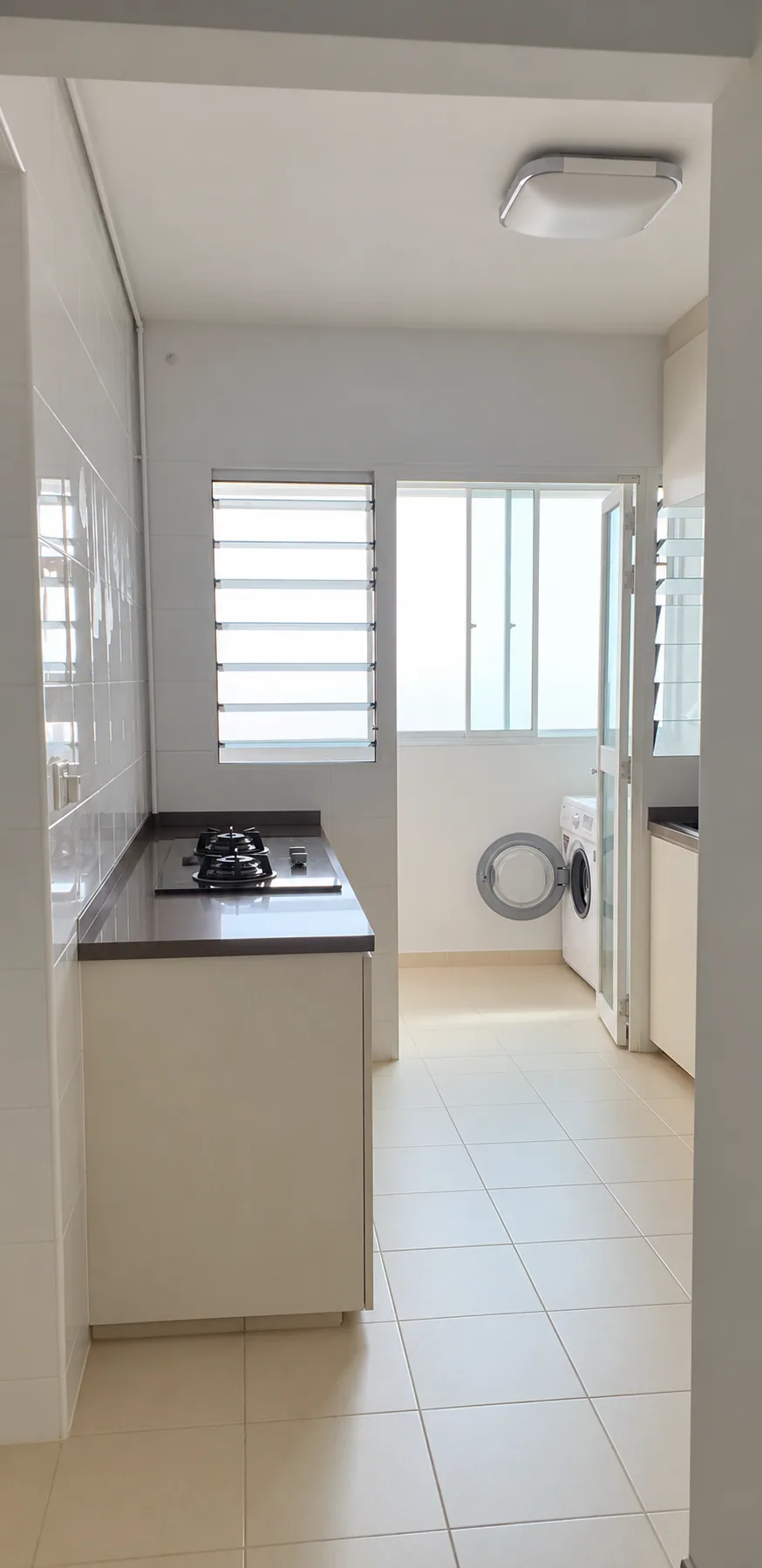 Privacy-edited Yishun HDB kitchen and service yard with pale cabinets and floor tiles