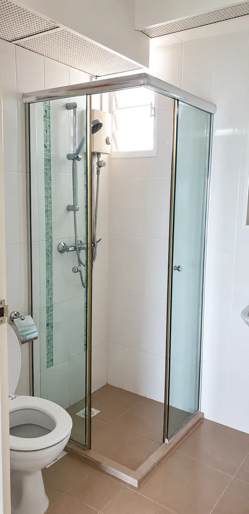 Privacy-edited Yishun HDB bathroom with a glazed shower enclosure and pale tiles